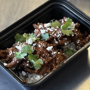 Birria Protein Bowl with white rice, black beans, pico de gallo, cilantro and topped with cotija cheese
