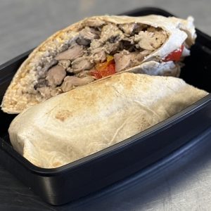 Shredded chicken burrito with rice, black beans, cottage cheese queso and roasted bell peppers